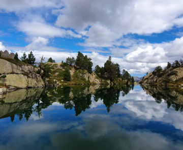 Lac de montagne avec reflets des reliefs dans l'eau dans les Encantats.