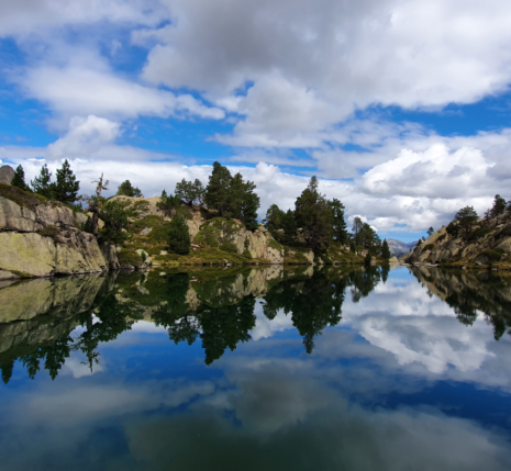 Lac de montagne avec reflets des reliefs dans l'eau dans les Encantats.