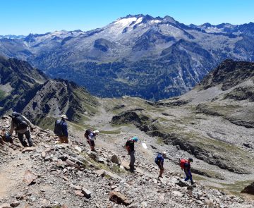 groupe de randonneurs dans le massif de l'Aneto en train de descendre sur un sentier de pierres