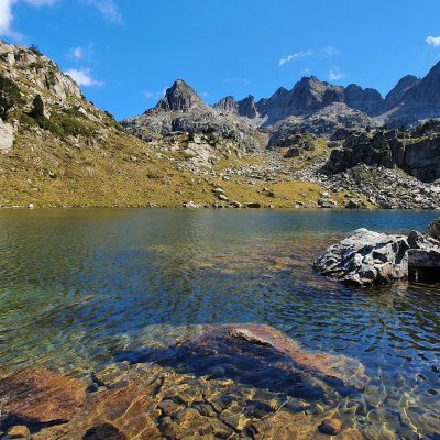 Randonneurs autour d'un lac de montagne lors d'un séjour de randonnée accompagnés d'un guide de montagne