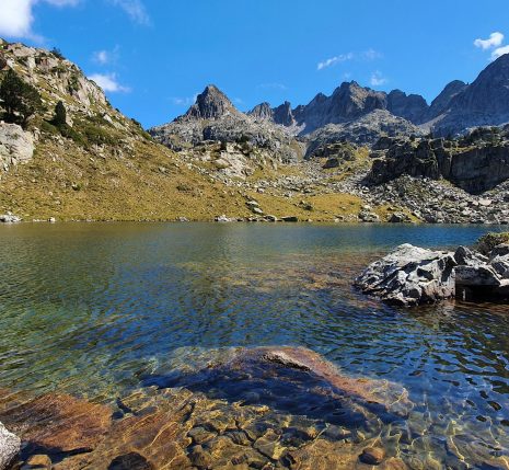 Randonneurs autour d'un lac de montagne lors d'un séjour de randonnée accompagnés d'un guide de montagne