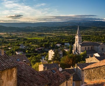 Bonnieux – 1 Un village perché dans le Lubéron au premier plan avec en fond une belle vu sur sur paysage avec des montagnes au loin