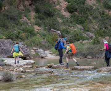 Groupe de randonneurs lors d'un séjour en liberté qui traversent l'eau d'un canyon au cours de leur randonnée