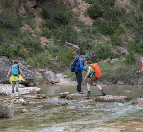 Groupe de randonneurs lors d'un séjour en liberté qui traversent l'eau d'un canyon au cours de leur randonnée