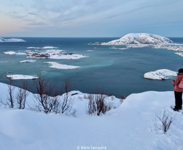 trek-raquettes-norvege Uns personne regarde l'horizon sur de la neige au bord de l'eau