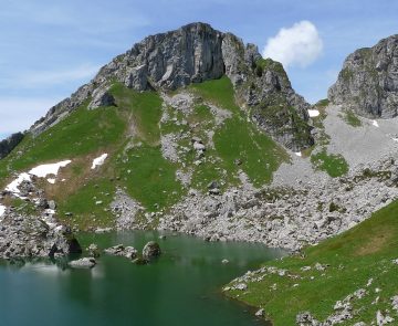 Paysage observé lors d'un séjour accompagné dans le massif du Chablais, avec au premier plan un lac de montagne surplombé par des sommets