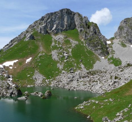 Paysage observé lors d'un séjour accompagné dans le massif du Chablais, avec au premier plan un lac de montagne surplombé par des sommets